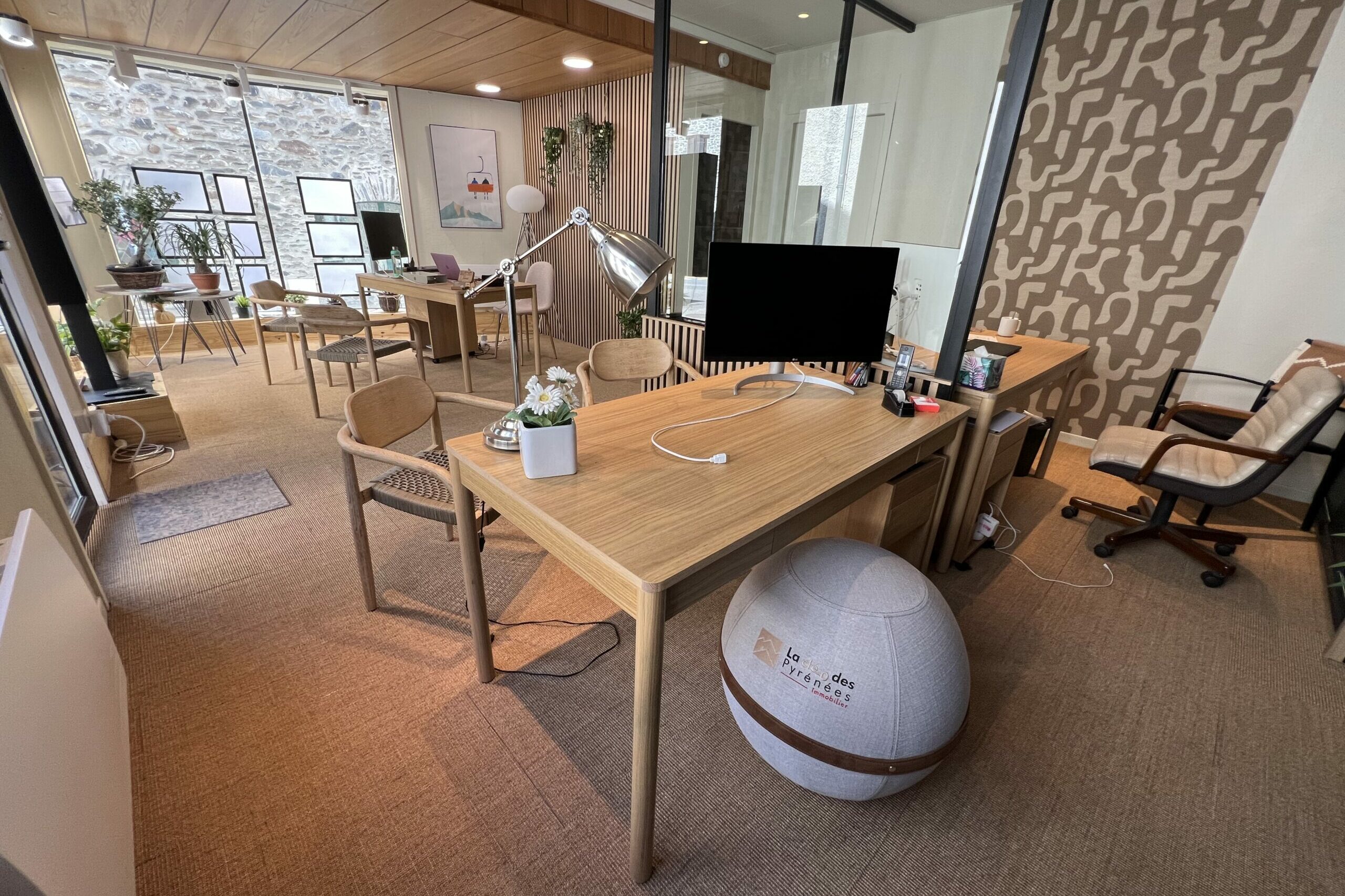 Intérieur de l'agence immobilière La Clé des Pyrénées à Saint-Lary-Soulan, bureaux en bois et espace de travail lumineux