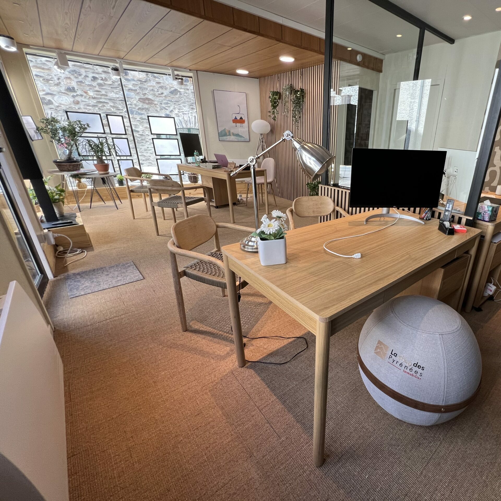 Intérieur de l'agence immobilière La Clé des Pyrénées à Saint-Lary-Soulan, bureaux en bois et espace de travail lumineux
