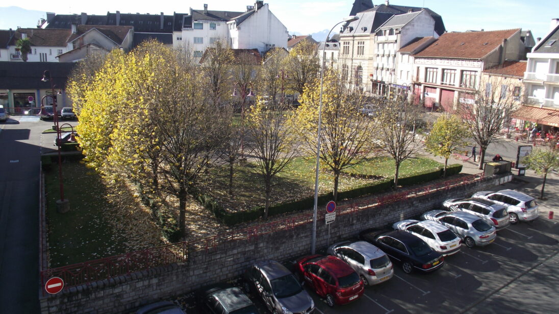 Vue aérienne sur la place de la République à Lannemezan avec arbres en automne et bâtiments du centre-ville